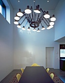 Retro pendant lamp with cantilever arms above dining table in minimalist room