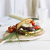 A grilled bread roll filled with vegetables and feta cheese