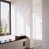 Modern bathroom with white interior, black accents and yellow vase