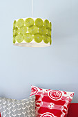 Pendant lamp with retro-patterned shade above colourful cushions