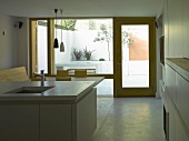 Kitchen island in open-plan kitchen with view of terrace