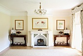 Traditional living room with chandelier and ornamental fireplace between antique console tables