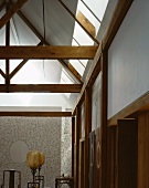 Dachkonstruktion aus Holz und antike Stehlampen mit Ballonschirm vor filigraner, flächiger Drahtskulptur mit eiförmigem Zentrum