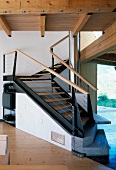Gewendelte Holz/Stahltreppe mit schrägen Elementen und Antrittsstufen aus Stein in zeitgenössischem Tiroler Holzhaus