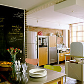 Kitchen with table, colourful chairs and blackboard wall