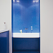 Badezimmer mit blauen Mosaikfliesen und Badewanne