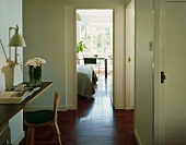 Hallway with seat & open door to bedroom