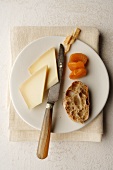 Alpine cheese, slice of bread and dried apricots