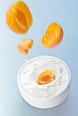 Peaches falling into yogurt