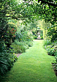 Gepflegter Gartenweg umgeben von vielfältiger Bepflanzung und Grünflächen