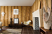 Living room with wood panelling, fireplace and rocking chair