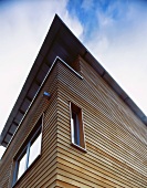 Blick nach oben auf Holzfassade eines modernen Wohnhauses