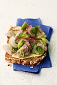 A slice of wholemeal bread topped with soused herring and spring onions