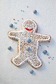 A gingerbread mean decorated with chocolate beans and icing sugar