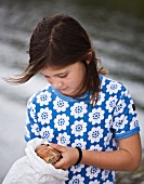 A girl taking a bread roll out of a paper bag