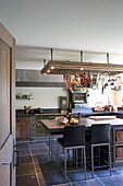 Rustikale Küche mit Metrofliesen und Hängegestell für Kochutensilien