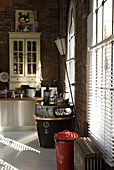 Vintage-style collector's items in loft kitchen lit from the side through large windows