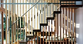 Partition of wooden bars between living room and staircase