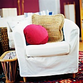 Chair with white cover and scatter cushions