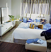 Bedroom with striped curtains and breakfast tray on bed