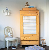 Wooden corner cupboard with glass door in child's bedroom