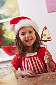Little girl showing a gingerbread Christmas tree