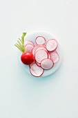 A whole radish and sliced radishes