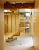 Wooden spiral staircase with curved glass wall