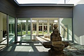 Old stone fountain in courtyard of modern villa