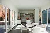Gedeckter Esstisch vor offener Küche im modernen Wohnhaus
