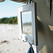 Mirror with coat pegs hanging on a tent