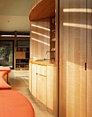 Moderner Wohnraum mit Minieinbauküche in Nische aus Holz