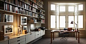 Modern library with desk in front of traditional bay window