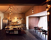 Made-to-measure glass counter with looped ceiling lights and dining area in stylish living space