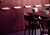 Tisch und Stühle vor Einbauschrank aus Holz