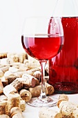 A bottle and a glass of wine and corks
