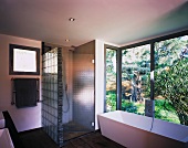 Badezimmer mit grosser Glasfront zum Garten