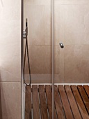 Tiled shower area with wooden slatted floor