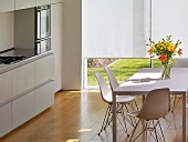 White dining table with shell chairs in modern kitchen