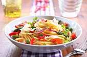 Spaghetti Tossed with Fresh Vegetables in a White Bowl with a Fork