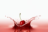 A cherry falling into red juice