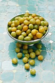 Fresh mirabelles, some in a bowl
