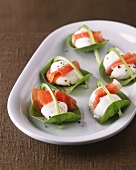 Mozzarella and Parma ham on spinach leaves