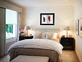 Light bedroom with black bedside cabinets and white bedside lamps