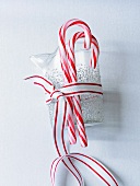 Two Candy Canes Tied to a Small Pitcher with Red and White Ribbon