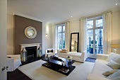 White, modern upholstered furniture and black coffee table in old building in London