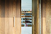 A view though an open wooden door onto a book shelf