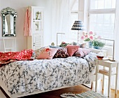Freundliches Schlafzimmer mit gemusterter Bettwäsche und Zierkissen