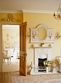 Oval, wood-framed mirror above open fireplace in Biedermeier room