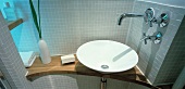 Designer washstand with white, ceramic basin and light grey mosaic wall tiles